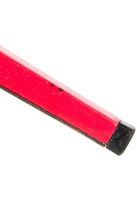 Gros plan d’une gomme rouge et noire avec des traces d’usure visibles et quelques légères taches de saleté sur sa surface.