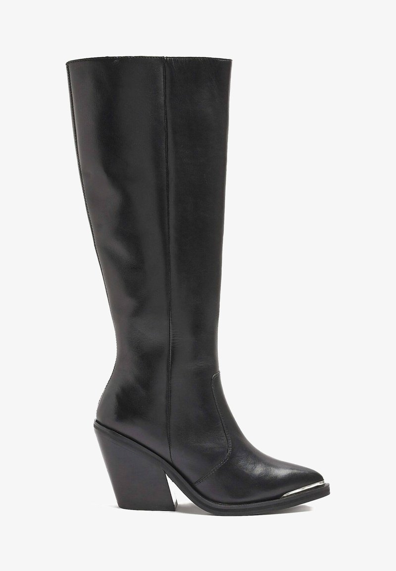 Botas de cuero negras hasta la rodilla con puntera afilada, tacón angular y detalles en plata en la punta. Textura suave, diseño elegante.