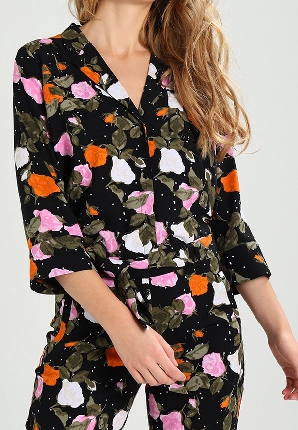 Conjunto de pijama floral con fondo negro y rosas en tonos rosa, blanco y naranja, hojas verdes, cuello y mangas tres cuartos.