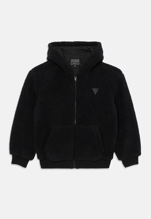 Sweat à capuche noir en polaire avec fermeture éclair, poches frontales, poignets et ourlet côtelés, et petit logo triangulaire sur la poitrine.