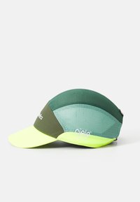 Grön och gul mesh löpkaps med en böjd skärm och en "ciele athletics"-logotyp på sidan och frampanelen.