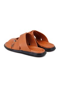 Bruine leren sandalen met kruisbandontwerp, textuur op de voetbed en een zwarte rubberen zool. Gladde afwerking met minimalistische details.