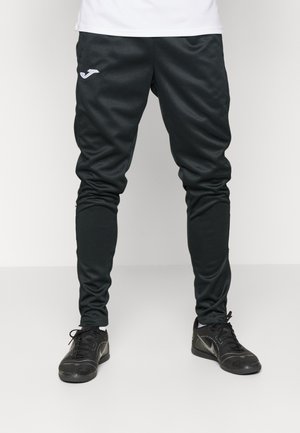 Pantalons de sport noirs en matériau doux et extensible, avec une coupe slim et un logo brodé sur la cuisse gauche.