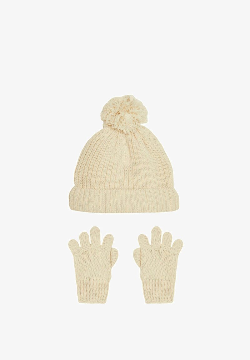 Kermanvärinen neulepipo, jossa on pom-pom päällä, yhdistettynä yhteensopiviin sormikkaisiin. Ominaisuuksina ribbitekstuuri ja pehmeä kangas.