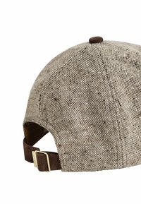 Cap made of textured brown tweed fabric with a curved brim, a brown suede adjustable strap, and a metal clasp on the back.