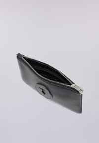 Clutch in pelle nera con chiusura a zip, caratterizzata da un logo circolare in rilievo e una superficie liscia; interno visibile.