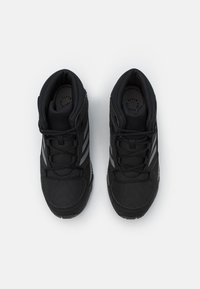 Czarne buty sportowe z syntetyczną cholewką, siateczkowymi panelami, okrągłymi sznurówkami i formowanymi gumowymi podeszwami. Posiadają trzy pionowe srebrne paski.