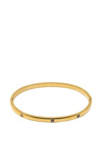 Złota metalowa bransoletka typu bangle o smukłym designie, z trzema równomiernie rozmieszczonymi przezroczystymi kryształami wtopionymi w jedną stronę. Gładka faktura, okrągły kształt.