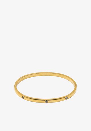 Złota metalowa bransoletka typu bangle o smukłym designie, z trzema równomiernie rozmieszczonymi przezroczystymi kryształami wtopionymi w jedną stronę. Gładka faktura, okrągły kształt.