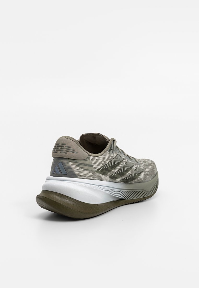 Zapatilla de running verde con un upper de tela texturizada, acentos grises, una suela blanca acolchada y el logo de tres rayas en el costado.