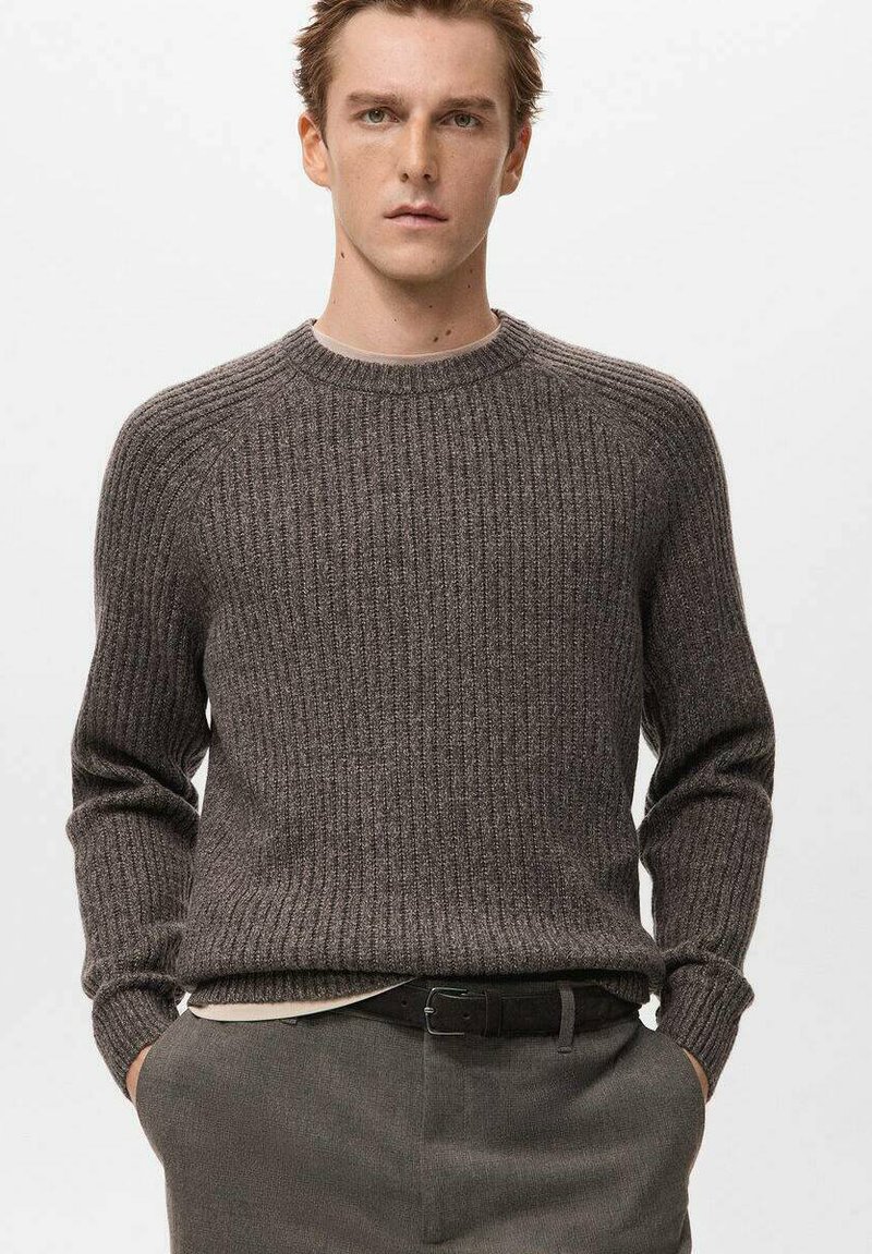 Szary sweter z prążkowanego dzianiny, z okrągłym dekoltem, długimi rękawami i teksturowaną powierzchnią. W połączeniu z ciemnymi spodniami i czarnym paskiem.