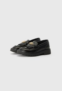 Svart lær loafers med fletteaktig tekstur, med en gullakcent på stroppen og en tykk gummisåle for godt grep.