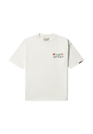 White cotton t-shirt featuring short sleeves, a crew neck, and a floral "PAS DE MONACO" print on the left chest.