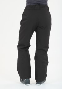 Pantalons de ski noirs à coupe droite, présentant une texture lisse et des genoux renforcés. La ceinture porte le nom de la marque "SLOPE."