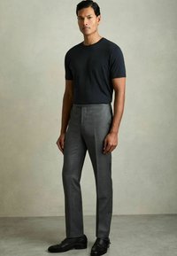 Tricou negru cu mânecă scurtă, asortat cu pantaloni gri ajustați și pantofi negri eleganți. Design simplu, adaptat pe corp, cu o textură fină.