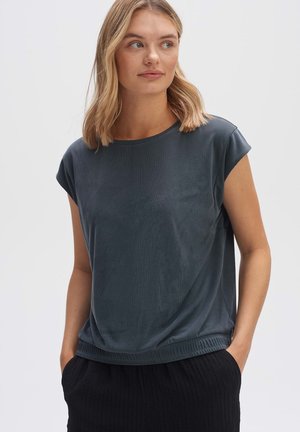 Dunkelgraues, kurzärmliges Oberteil mit lässiger Passform, weichem Material und geripptem Saum, kombiniert mit einem schwarzen, gefalteten Rock.