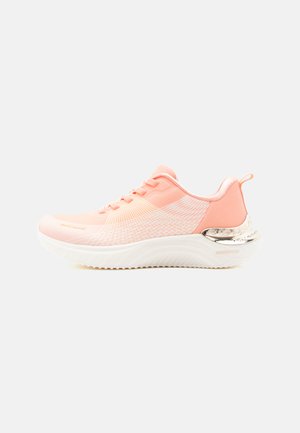 Sneaker sportiva di colore rosa chiaro con suola bianca, motivo a rete dettagliato, chiusura frontale con lacci e accento metallico sulla linguetta del tallone su sfondo bianco.