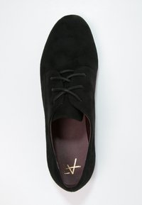 Chaussure en daim noir à lacets avec un bout arrondi et une surface texturée ; présente un intérieur bordeaux et un détail logo doré sur la semelle intérieure.