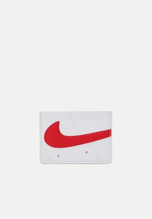 Tarjetero blanco hecho de material sintético suave, con un prominente logotipo de swoosh rojo de Nike y sutiles detalles de costura.