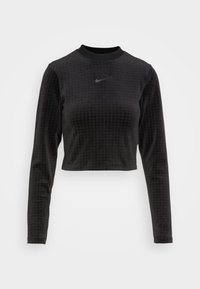 Svart cropped långärmad topp i texturerat material, med rund hals och en liten svart Nike-logotyp på bröstet.