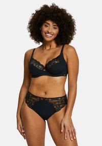 Ensemble de lingerie noire comprenant un soutien-gorge à texture côtelée avec des détails en dentelle et un shorty taille haute assorti en dentelle. Accent en forme de trou de serrure au centre.