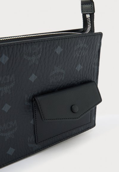 Μαύρη δερμάτινη τσάντα με υφή, που διαθέτει θήκη με καπάκι και κούμπωμα με σούστα καθώς και ανάγλυφο λογότυπο σε όλη την επιφάνεια.