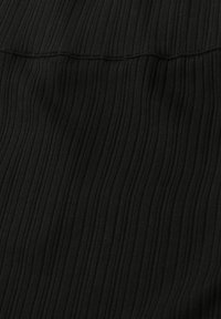 Tissu côtelé noir avec une texture tricotée verticale visible et une couture horizontale près du haut.