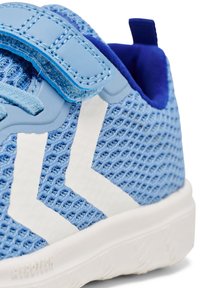 Blå nät sneakers med vit chevron-design. Har en blå rem och foder, strukturerad ovandel och en vit gummisula.