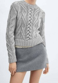 Szary sweter z dzianiny o splocie w warkocze, okrągłym dekolcie, oraz prążkowanych mankietach i dole. Połączony z szaro dopasowaną spódnicą. Miękka tekstura.