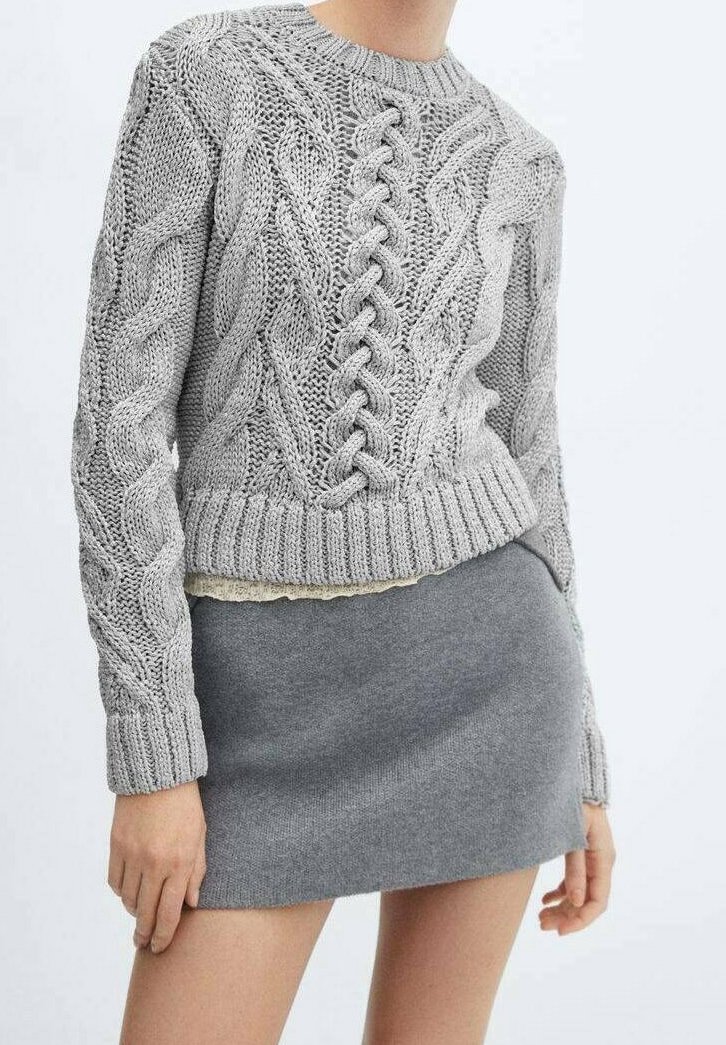 Szary sweter z dzianiny o splocie w warkocze, okrągłym dekolcie, oraz prążkowanych mankietach i dole. Połączony z szaro dopasowaną spódnicą. Miękka tekstura.