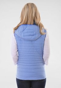 Blauer gesteppter Weste mit Kapuze, die ein strukturiertes Muster aufweist, mit Reißverschluss und einer körpernahen Passform. Über einem weißen Langarmshirt getragen.
