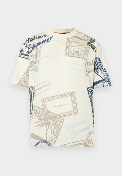 Βαμβακερό μπλουζάκι σε κρεμ χρώμα με πολύχρωμα γραφικά σχέδια, που περιλαμβάνουν γραμματόσημα και κείμενο «Italian Summer» σε μπλε, πράσινους και καφέ τόνους.