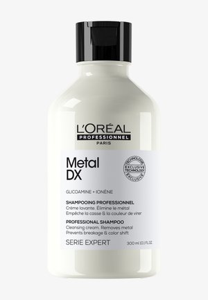 L'Oréal Professionnel Metal DX Shampoo-Flasche mit schwarzem Deckel, gekennzeichnet als professionelle Reinigungspflege, die Metall entfernt und Haarbruch verhindert.