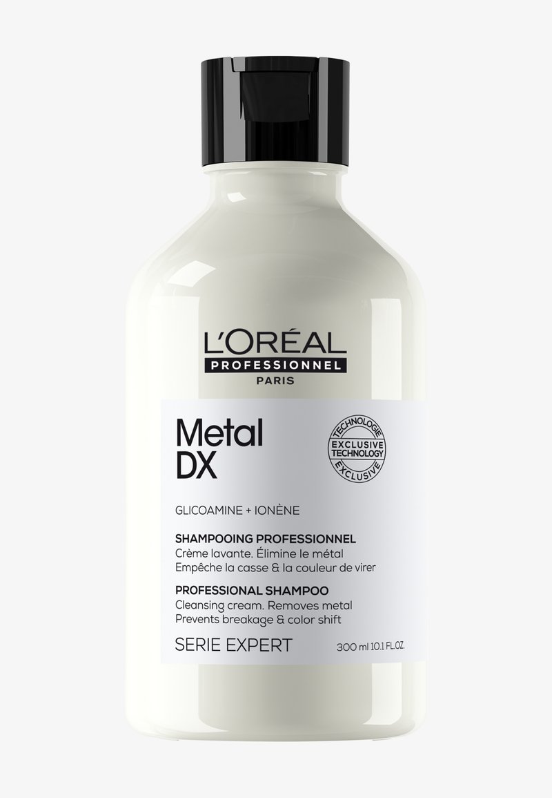 Butelka szamponu L'Oréal Professionnel Metal DX z czarną nakrętką, oznaczona jako profesjonalny krem oczyszczający, który usuwa metal i zapobiega łamaniu się włosów.