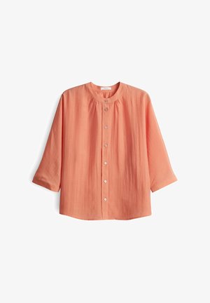 Koralle-farbenes Hemd mit Knopfleiste, rundem Halsausschnitt und Dreiviertelärmeln. Hergestellt aus leichtem Stoff mit strukturiertem Finish undraffiniertem Detail.