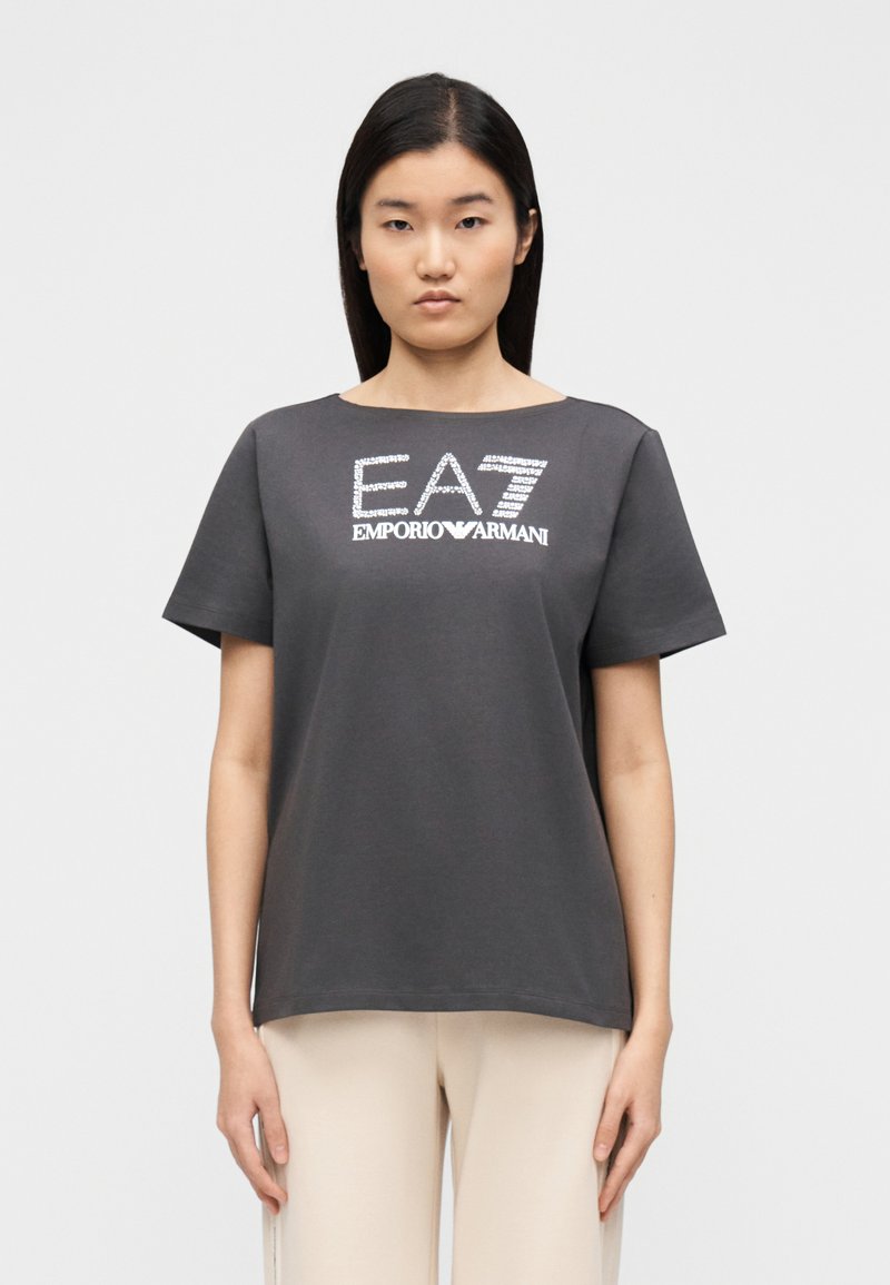 Szara koszulka z krótkim rękawem z fakturowanym srebrnym logo "EA7 EMPORIO ARMANI" na przodzie. Wykonana z miękkiego bawełnianego materiału.