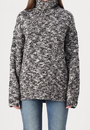 Turtleneck sweater made of textured knit fabric in black and white. Oversized fit with dropped shoulders, featuring a casual, chunky design.