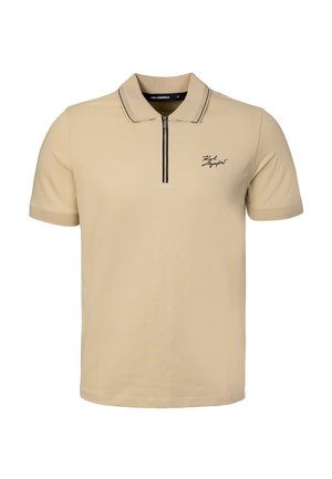 Polo beige manches courtes avec fermeture éclair à l'avant, bordure noire au col et petit logo noir script sur la poitrine gauche.