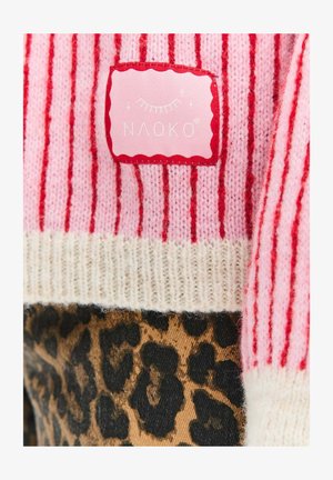 Růžový pruhovaný svetr s bílým žebrovaným lemem a červenou štítkem s nápisem "NAOKO." Dolní část zdobí leopardí vzor.