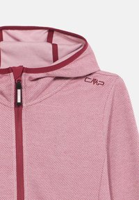 Ανοιχτό ροζ ζακέτα με φερμουάρ και υφή, μπορντό λεπτομέρειες και κουκούλα. Διαθέτει φερμουάρ μπροστά και ένα μικρό λογότυπο στον ώμο.