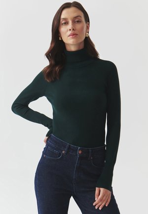 Maglione a collo alto di un verde scuro realizzato in un materiale a maglia liscia, silhouette aderente, con maniche lunghe e dettagli a coste sul colletto.