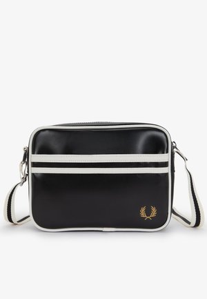 Bolso rectangular negro de bandolera con ribete blanco y dos rayas horizontales blancas, correa ajustable y pequeño logo de corona de laurel dorada.