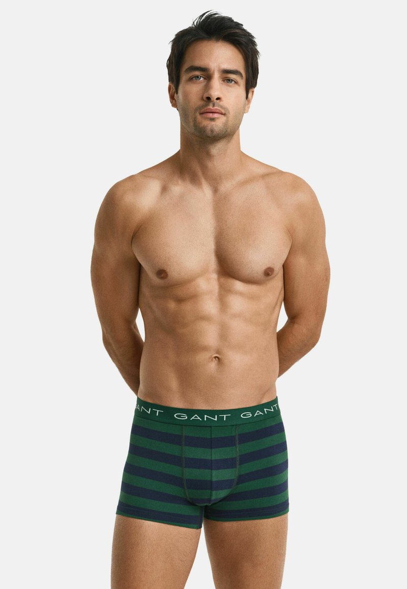 Boxer briefs a rayas verde y azul marino con una cinturilla elástica con marca. Tejido suave, diseño ajustado y detalle de bolsa en la parte frontal.