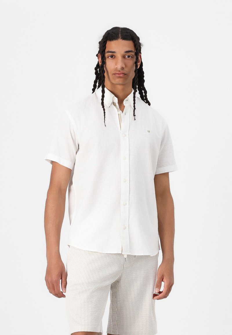 Korte mouwen witte linnen shirt met een button-down kraag, voorzien van een klein logo. Gecombineerd met beige gestreepte shorts. Geweven materiaal.