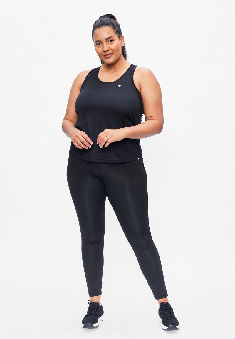 Zwarte sporttanktop met ronde hals, gecombineerd met zwarte strakke leggings. Model draagt zwarte sportschoenen. Glad, lichtgewicht materiaal.
