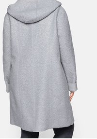 Grijze hoodiejas met een geweven stof met bloemmotieven, lange mouwen en zijnaad voor een op maat gemaakte pasvorm.
