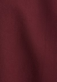 Tessuto bordeaux con una superficie liscia e testurizzata, caratterizzato da un motivo di trama diagonale. Il colore è profondo e ricco, aumentandone la profondità visiva.
