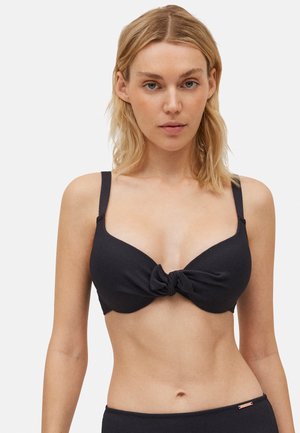 Top de bikini negro hecho de material texturizado, con un diseño de nudo torcido en el centro y tirantes ajustables.