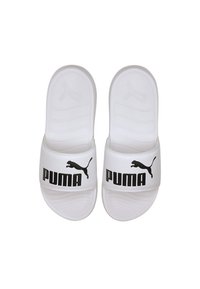 Sandales blanches à enfiler avec une semelle texturée, arborant un logo Puma noir et une silhouette noire de puma sur la sangle.
