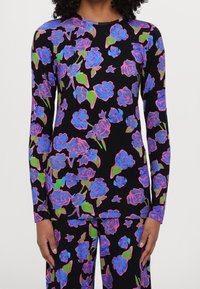 Długi rękaw, górna część w miękkiej tkaninie z czarnym tłem oraz jaskrawymi różami w kolorze niebieskim, różowym i zielonym, okrągły dekolt, dopasowany krój.